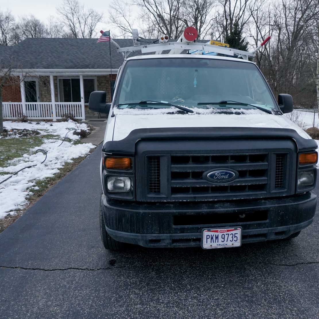 Van in front of a house in winter with snow. 